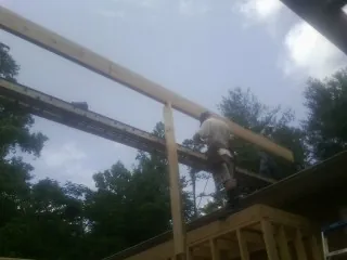 Carpenter setting a ridge beam over a new addition frame — Ice Dam Removal by Roofing Brothers in Knowlesville