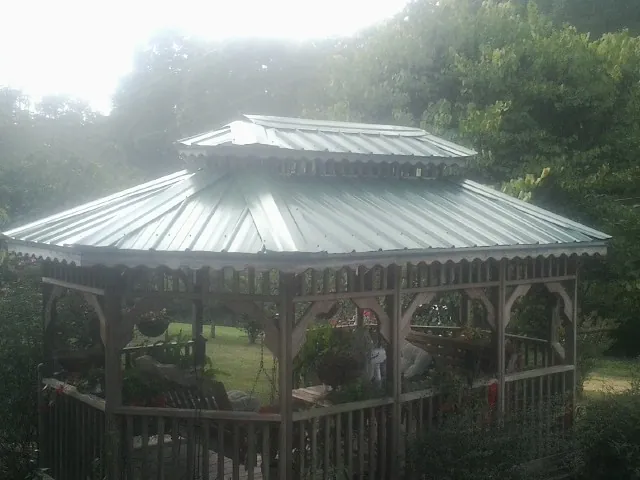 Two tier green metal roof on a garden gazebo in Knowlesville