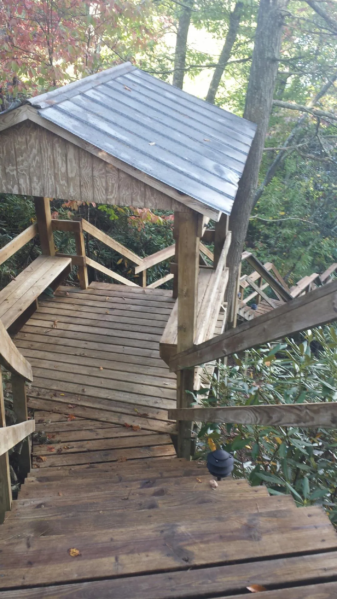 Metal roofed shelter over wooden steps on a wooded walkway — Skylight Repair & Installation work by our crew in Knowlesville